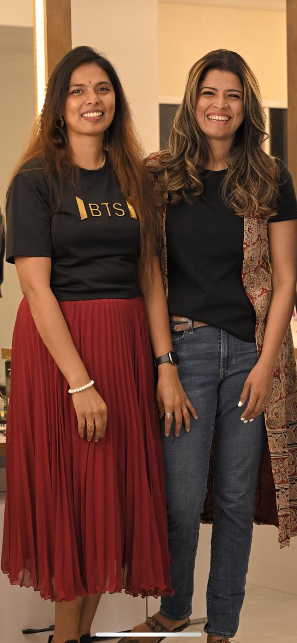 Two women smiling together inside the salon