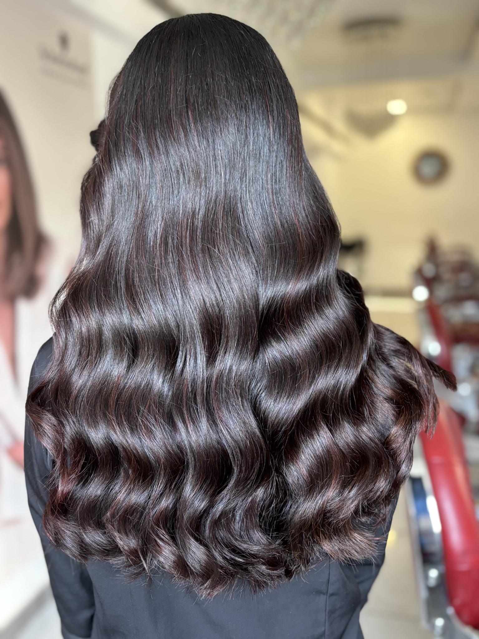 Long dark hair styled in soft waves at Greatlooks Salon